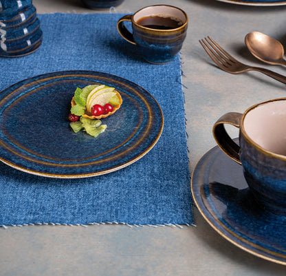 Ariane Splash Denim Coupe Deep Plate in a styled table setting